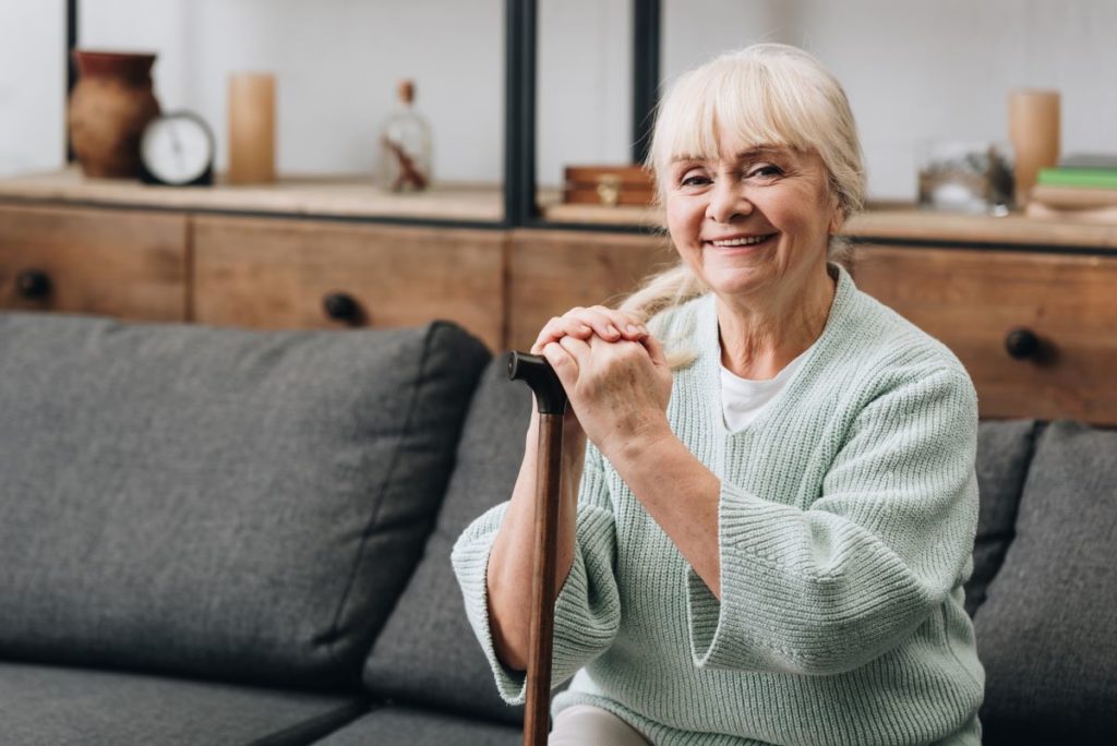 senior lady with alzheimer's disease sitting on sofa in home